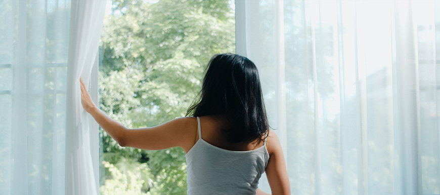 Woman opening window to cool breeze